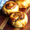 Three cinnamon rolls on a wooden surface