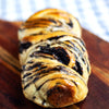Braided eggless Dark Chocolate Babka with chocolate swirls on a wooden board