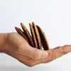 Hand holding four almond flour chocolate chip cookies against a white background