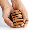 Hand holding a stack of gluten free butter cookies on a white background