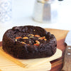 Eggless Almond Fudge Brownie topped with roast almonds on a wooden board.