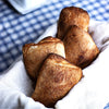 Four freshly baked vegan Ciabatta bread on a table with a chequered table cloth