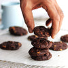 A stack of freshly baked gluten free dark chocolate brookies on a cooking rack