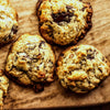 Close up of New York Chocolate Chip Walnut Cookies on a wooden board