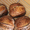 Freshly baked sourdough country loaves on a cooling rack.
