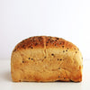 Loaf of sourdough sandwich bread with sesame seeds on a white background