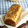 Artisanal whole wheat sandwich bread with seeds on a wooden board with a blurred background