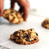 Freshly baked eggless New York Style Rum and Nut cookies on a cooling rack with a blurred background.